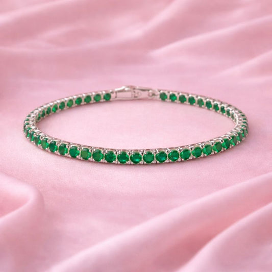 Green gemstone bracelet on a pink fabric background – Emerald Aura Tennis Bracelet – Silver-Tone Demi-Fine Jewellery for Women