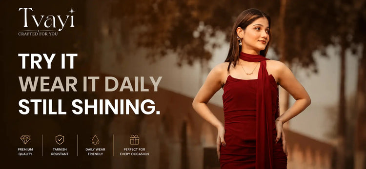 A woman modeling a deep red halter-neck dress with a draped shawl, set against a warm, blurred outdoor background. The left side features a dark overlay with the brand name 'Tvayi' and promotional text 'TRY IT WEAR IT DAILY STILL SHINING.'