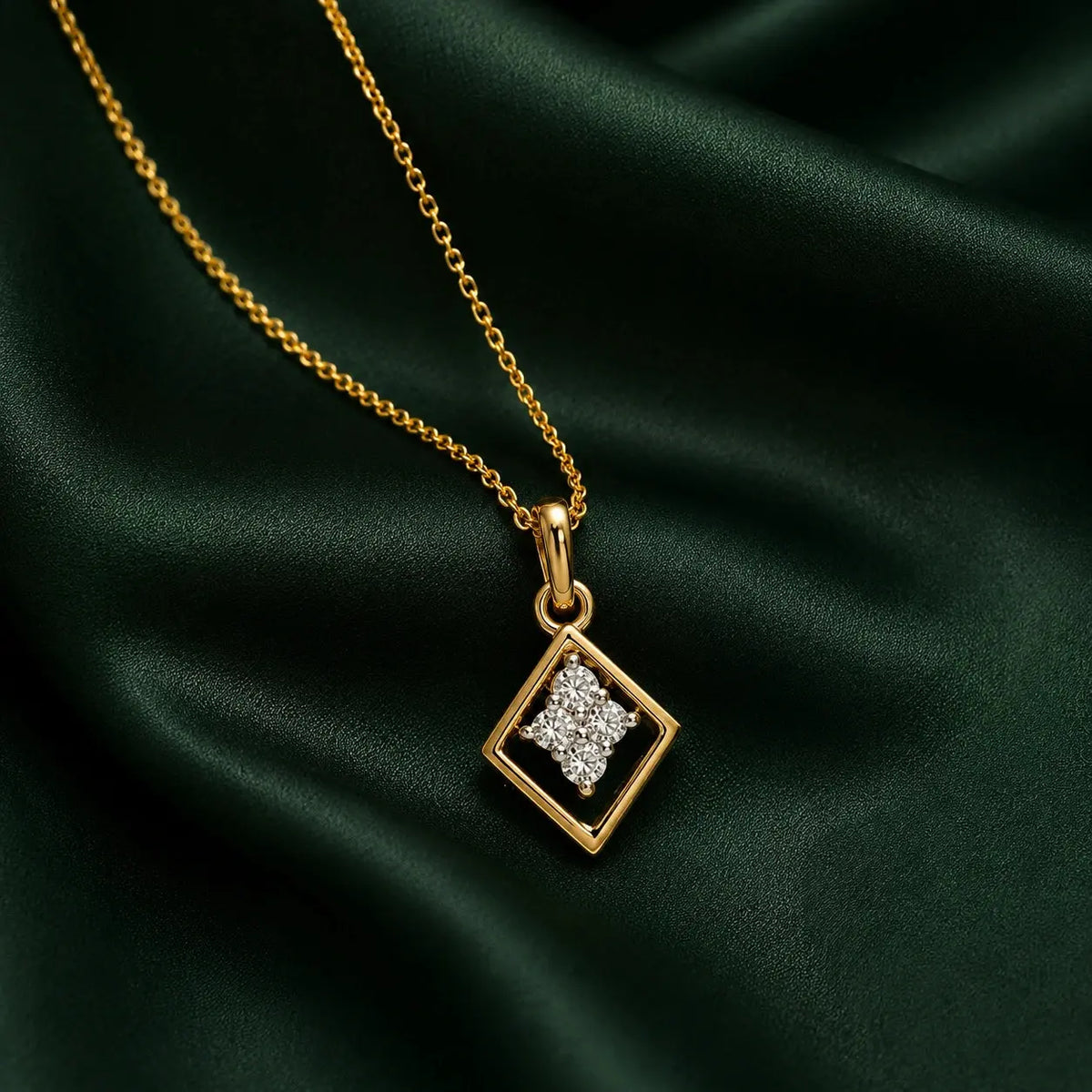 A gold chain necklace with a diamond-shaped pendant featuring a clear crystal star in the center, displayed on a draped dark green satin fabric. – Geometric Spark Diamond Pendant Necklace
