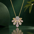 A gold pendant necklace with a fan-shaped Art Deco design, featuring lavender enamel inlays and sparkling clear stones, displayed on a dark green reflective surface. – Lavender Cascade Lab-Grown Diamond Necklace