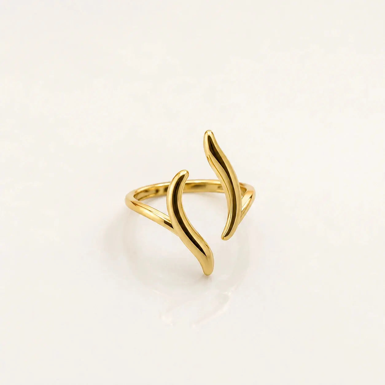 A gold open ring with a minimalist, abstract wavy design, photographed on a clean white background. – Luna Wave Adjustable Ring