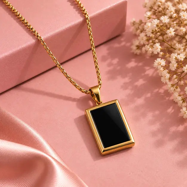 Noiré Gold Plated Black Rectangular Pendant Necklace detailed view on luxury pink background – TVAYI